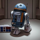 A blue and orange droid sits on a pedestal, part of the scene at Galactic Starcruiser.